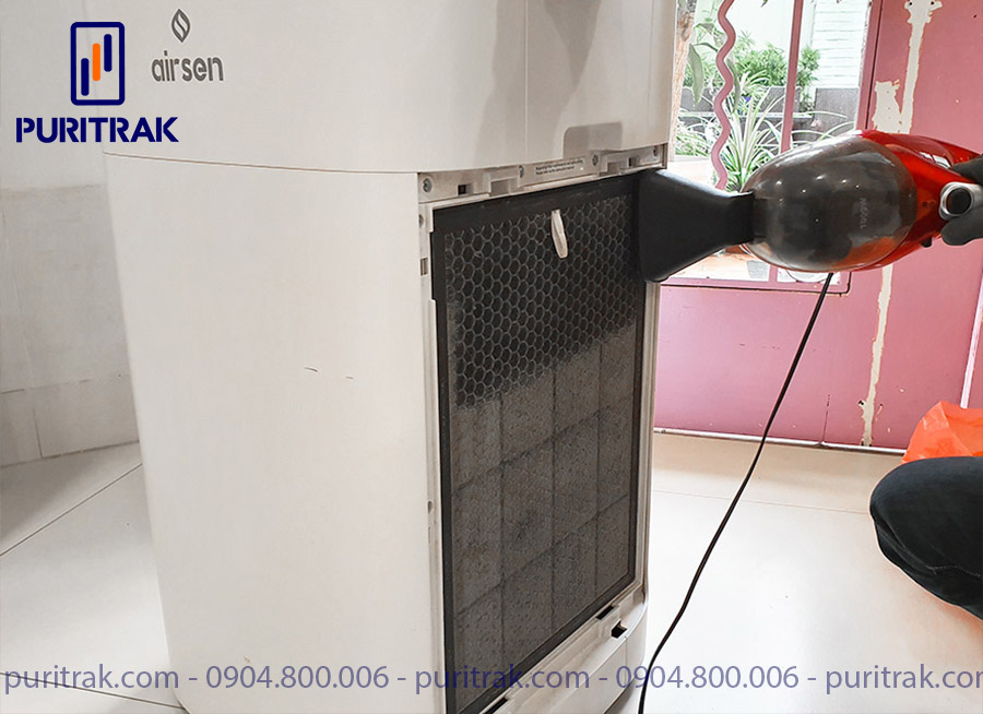 Technical staff cleans the activated carbon filter of the air purifier with a vacuum cleaner