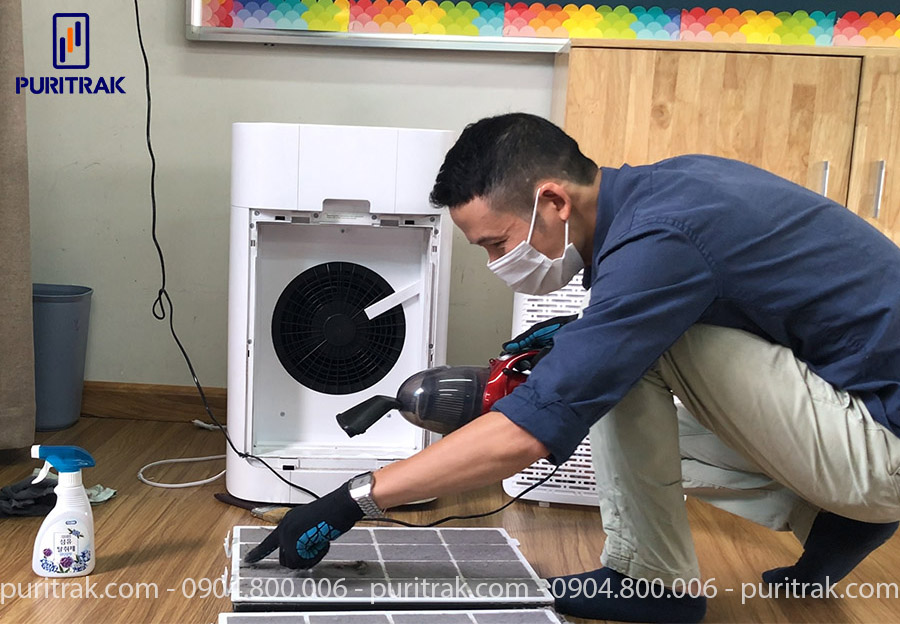 The technical staff of Puritrak is cleaning the filter of the air purifier.